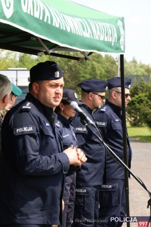 Na zdjęciu Dyrektor Biura Kryminalnego insp. Gregorz Napiórkowski podczas oficjalnego powitania gości i uczestników ćwiczeń. Stoi przemawiając do mikrofonu.