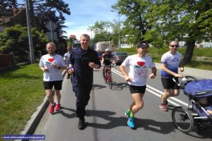 Policjant biegnący w mundurze w grupie biegaczy