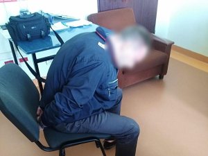 zatrzymany mężczyzna siedzi na krześle, ręce ma w kajdankach