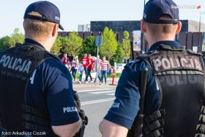 policjanci obserwują kibiców zmierzających na mecz