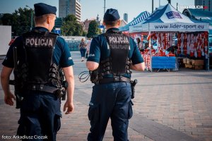 policjanci obserwują kibiców zmierzających na mecz