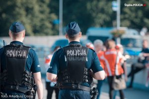 policjanci obserwują kibiców zmierzających na mecz