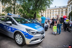 Mężczyzna z dzieckiem ogląda oznakowany radiowóz policyjny