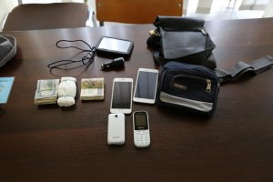 zabezpieczone przez policjantów przedmioty: telefony komórkowe, pliki z pieniędzmi, nawigacja samochodowa, saszetki