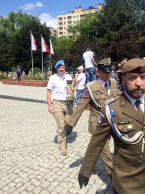 maszerujący żołnierze podczas uroczystości, jeden z nich trzyma puchar