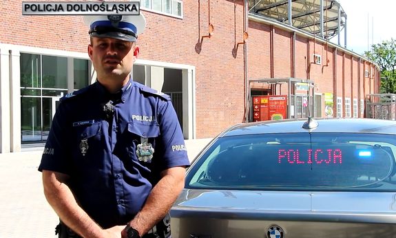 policjant stoi przy radiowozie