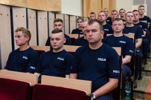 Nowi policjanci w bocznych rzędach auli, lewa strona.