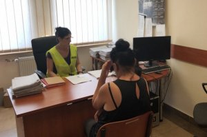 policjantka za biurkiem przesłuchuje właścicielkę psa