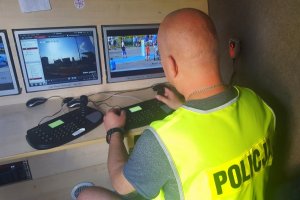 policjant obserwuje monitory kamer z Mobilnego Centrum Monitoringu