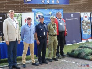 organizatorzy zawodów stoją w szeregu na tle rolupów