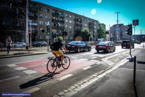 Mężczyzna jadący rowerem pasem ruchu dla rowerów