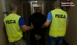 dwaj policjanci prowadzą zatrzymanego mężczyznę
