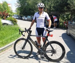 Izabela Kłosowska w stroju sportowym stoi z rowerem