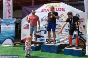 Zawodnicy Triathlonu z pucharami na podium