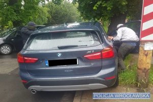 policjanci kryminalni podczas zatrzymywania mężczyzn, którzy poruszali się skradzionym samochodem marki BMW