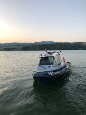policjant w łodzi policyjnej na jeziorze