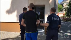 dwaj policjanci prowadzą zatrzymanego mężczyznę