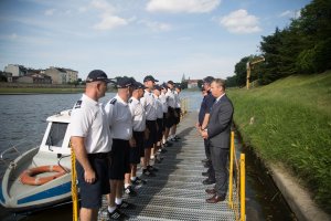 8 policjantów komisariatu wodnego stoi na pomoście naprzeciwko Wojewoda Małopolski Piotr Ćwik oraz Komendant Wojewódzki Policji nadinspektor dr Krzysztof Pobuta