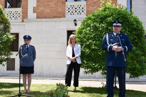 Komendant Wojewódzki Policji w Katowicach nadinsp. Krzysztof Justyński przemawia stojąc przy mikrofonie obok stoi polska policjantka i inna kobieta