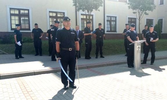 uczestnicy szkolenia na placu jeden z nich z szablą w dłoni