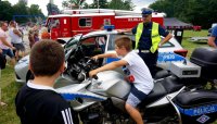 policjant stoi przy radiowozie podczas pikniku