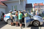 dzieci stoją przy radiowozie