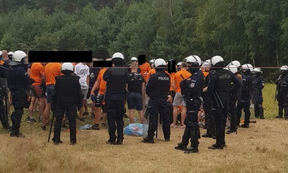 grupa pseudokibiców otoczona przez policjantów z OPP