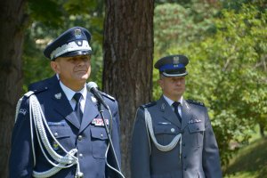 dwaj policjanci, jeden z nich stoi przy mikrofonie