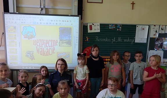 Na zdjęciu widoczna jest grupa dzieci z policjantką.