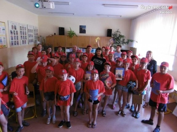 Zdjęcie przedstawia grupę dzieci ubranych w jednakowe czerwone stroje.