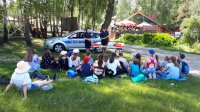 policjanci rozmawiają z dziećmi na spotkaniu profilaktycznym o bezpieczeństwie nad wodą