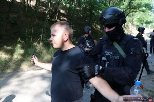 policjant przeszukuje osobę