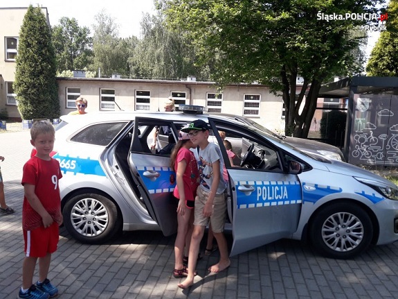 Na zdjęciu widoczne są dzieci oglądające radiowóz.