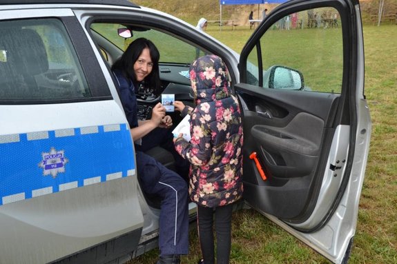 policjantka w radiowozie rozmawia z dzieckiem