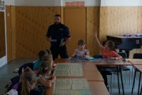 policjant rozmawia z dziećmi o bezpieczeństwie