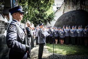 Przemówienie prowadzącego uroczystość w tle policjanci w szeregu