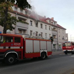 Kłęby dymu z okna mieszkania i stojące na ulicy wozy strażackie