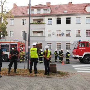 Policjanci oraz strażacy wykonują czynności w związku z pożarem mieszkania