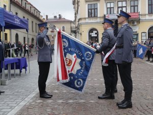 policjanci ze sztandarem podczas uroczystości na placu