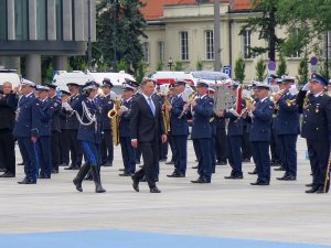 Prezydent Andrzej Duda w asyście Komendanta Głównego Policji dokonuje przeglądu pododdziałów, przechodzą przed orkiestrą policyjną