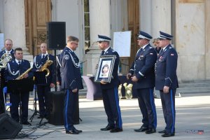 Zastępcy Komendanta Głównego Policji wręczają wyróżnienie dyrygentowi orkiestry