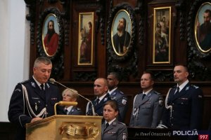 Policjant odczytuje wezwania w Modlitwie Wiernych
