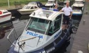 Na zdjęciu widoczny jest policjant wraz ze służbową łodzią motorową
