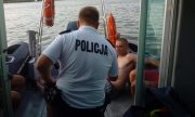 Załoga policyjnej łodzi motorowej oraz mężczyzna wyciągnięty z wody.