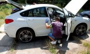 Policjanci przeszukują odzyskane białe BMW