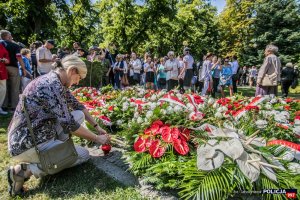 grupa ludzi i złożone kwiaty