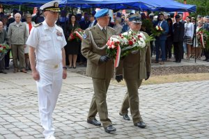 Polscy i amerykańscy żołnierze składają kwiaty pod pomnikiem.
