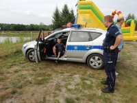 policjant stoi przy radiowozie
