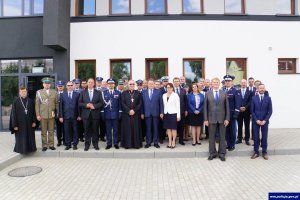 Pamiątkowe zdjęcie pod Komisariatem Policji w Korszach. Na zdjęciu widoczni są uczestnicy uroczystości.