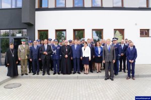 Pamiątkowe zdjęcie pod Komisariatem Policji w Korszach. Na zdjęciu widoczni są uczestnicy uroczystości.